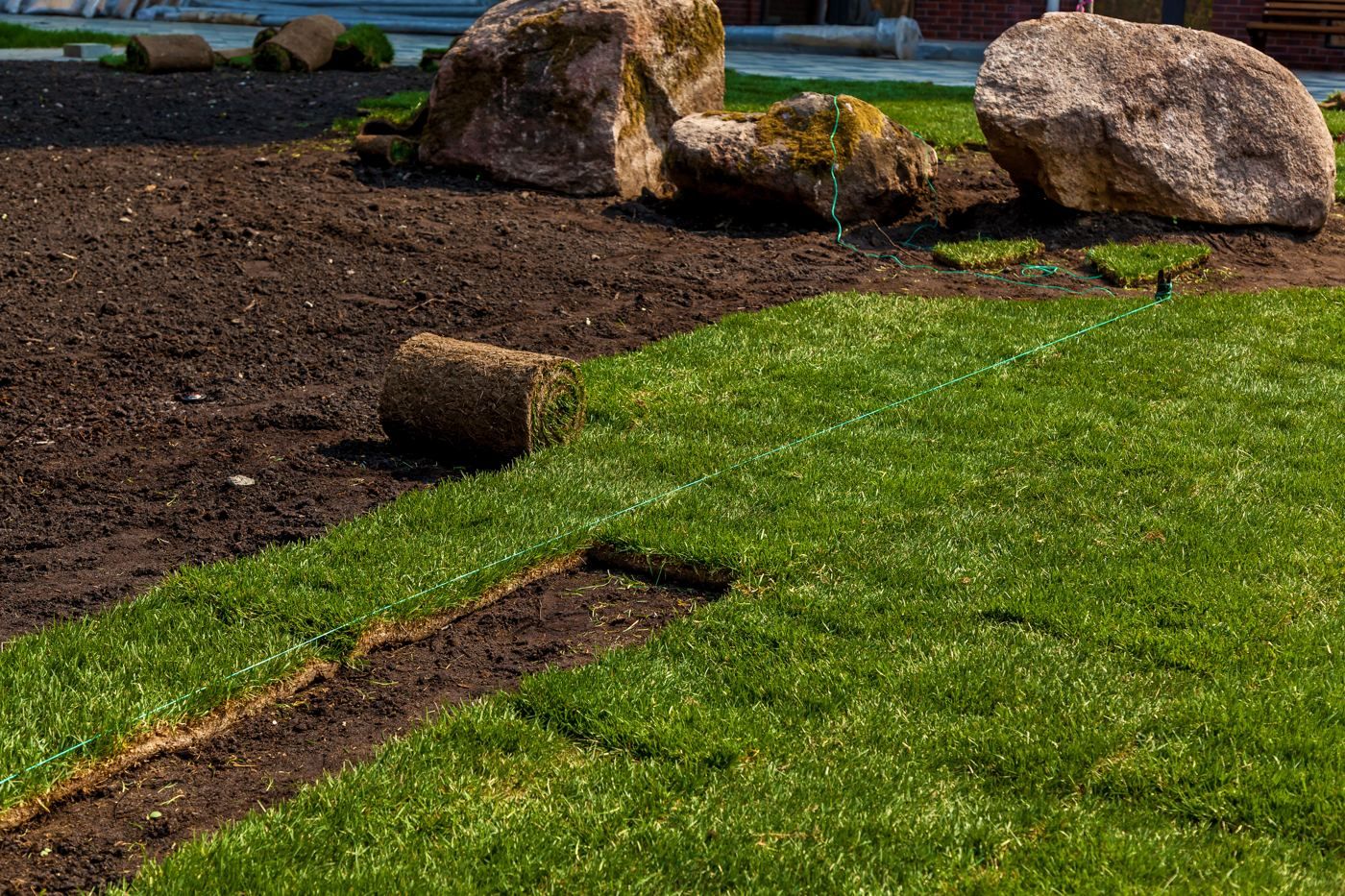 Residential sod installation with rolls of fresh turf being laid in New Jersey